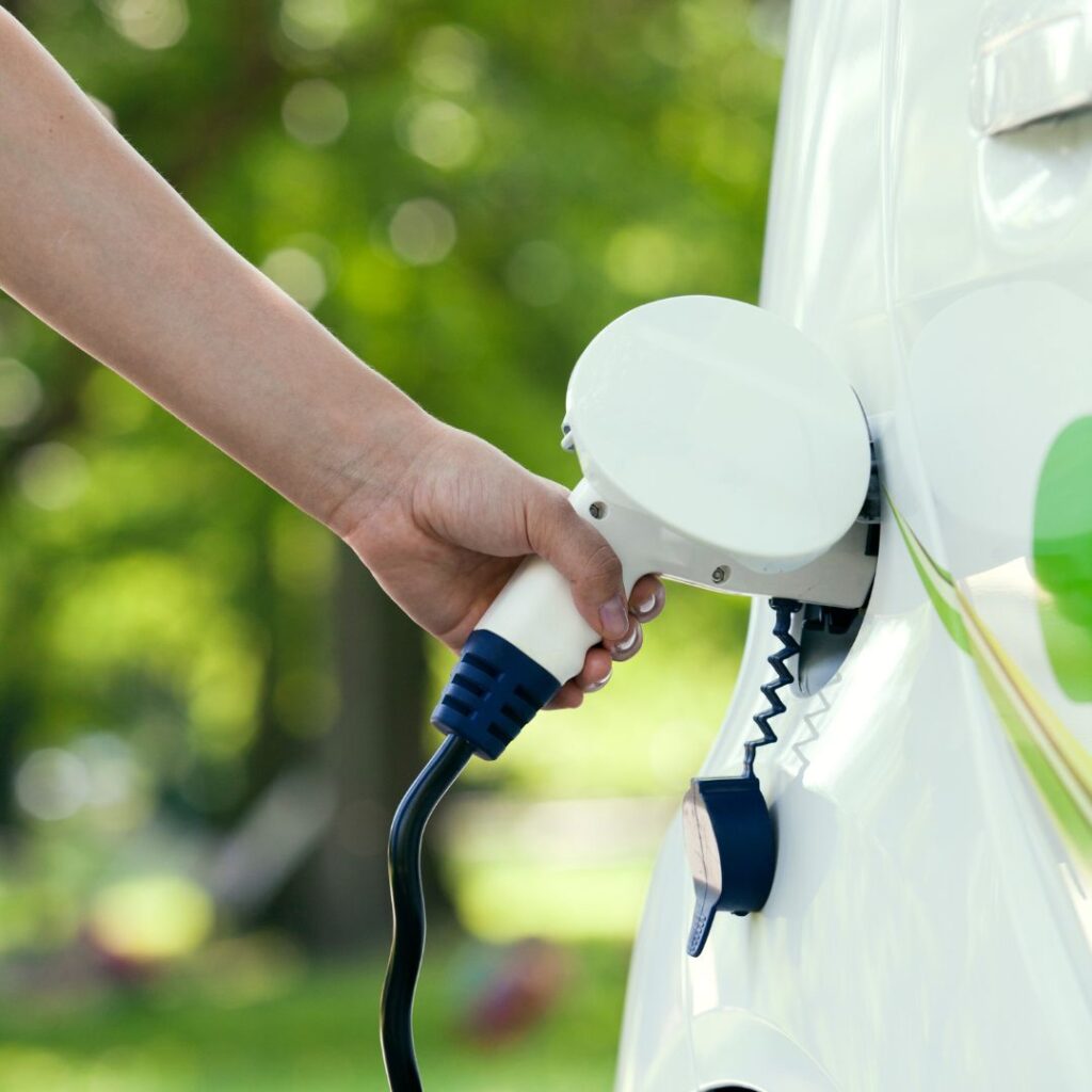 Hand Holding Electric Car Charger