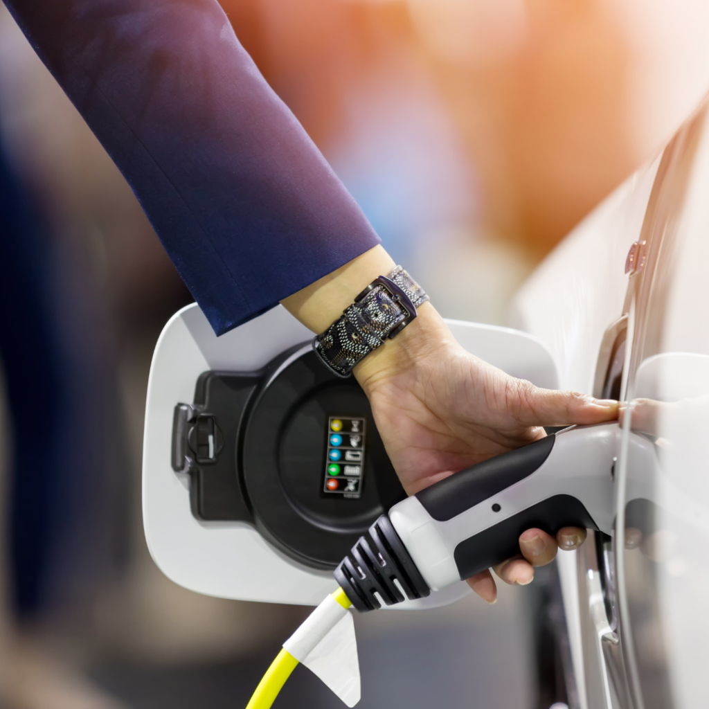 Hand holding Electric car charger. Electric Vehicle EV Charging station and Charger. Human hand is holding Electric Car Charging connect to Electric car.