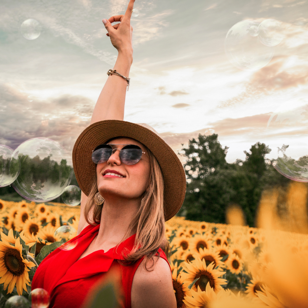 Woman Surrounded by Sunflowers Raising Hand