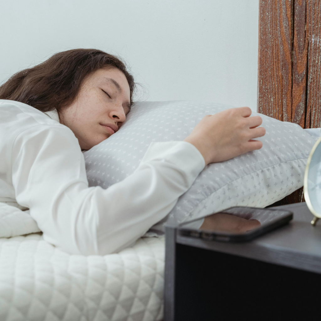 Young female sleeping on bed in morning