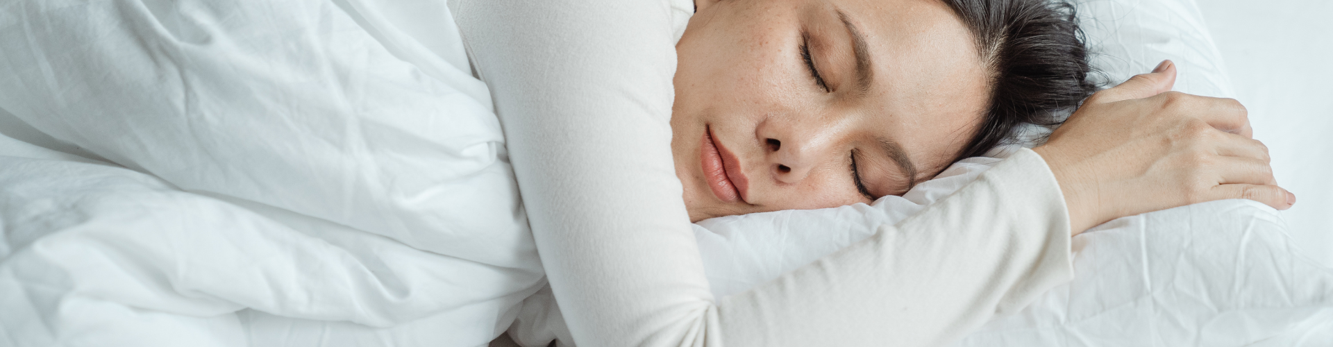 Woman sleeping in bed near smartphone