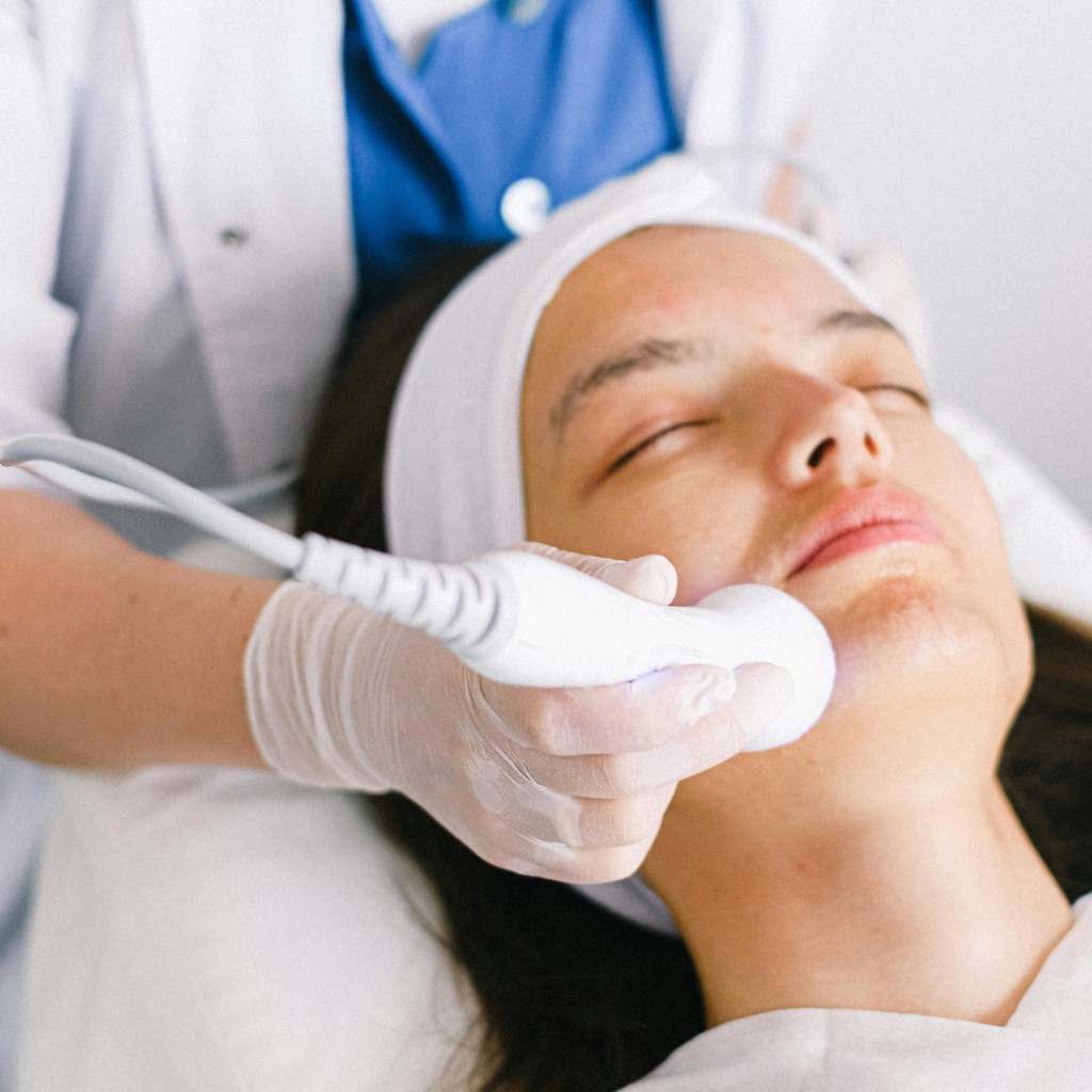 Beautician doing ultrasonic face cleaning for young client