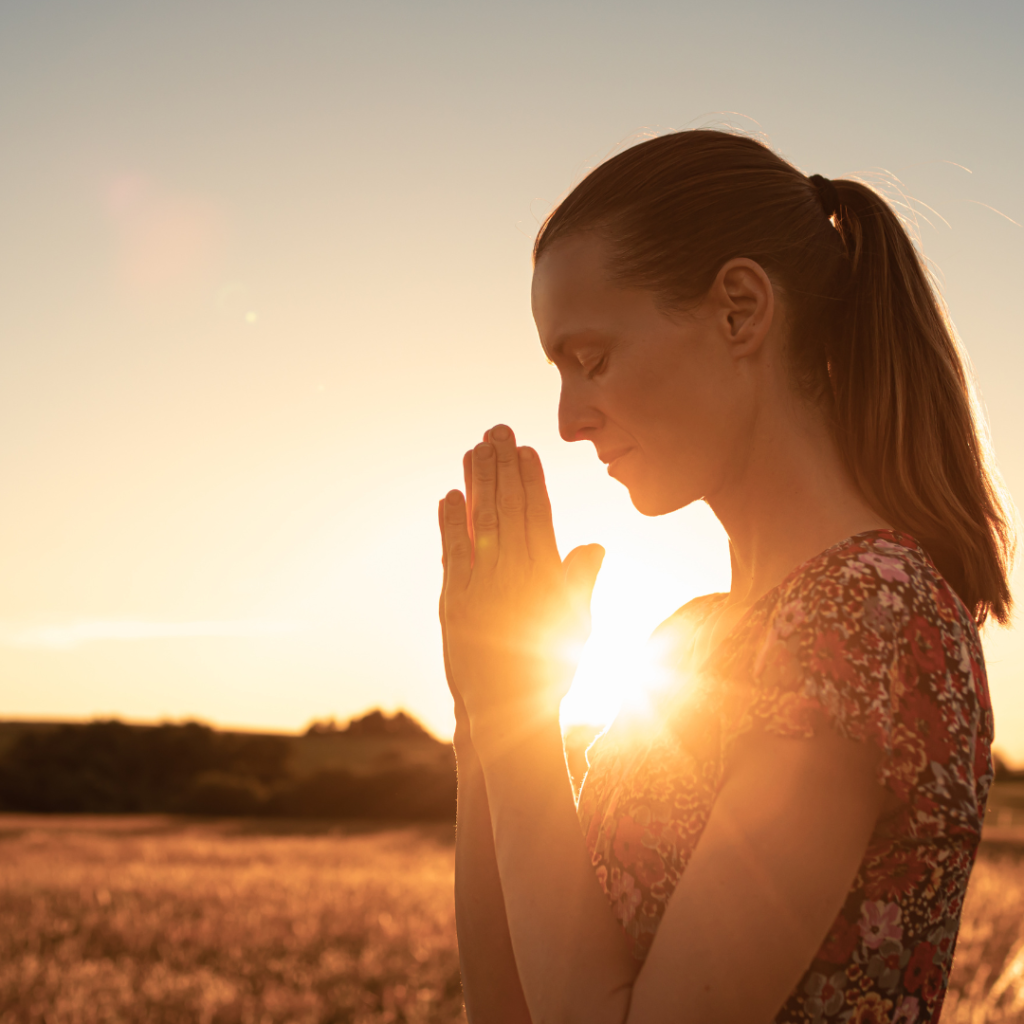 Woman with praying hands worshiping god