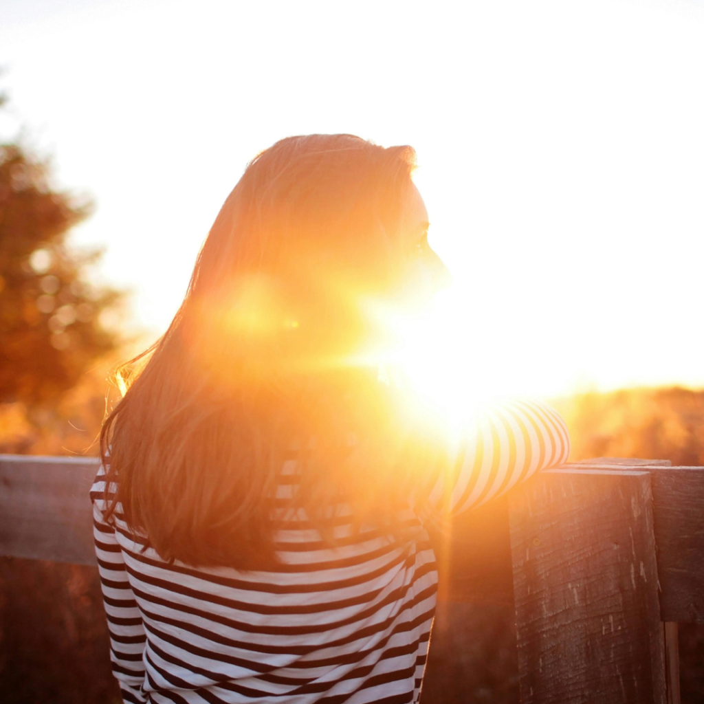 Woman Standing in Balcony during Sunset