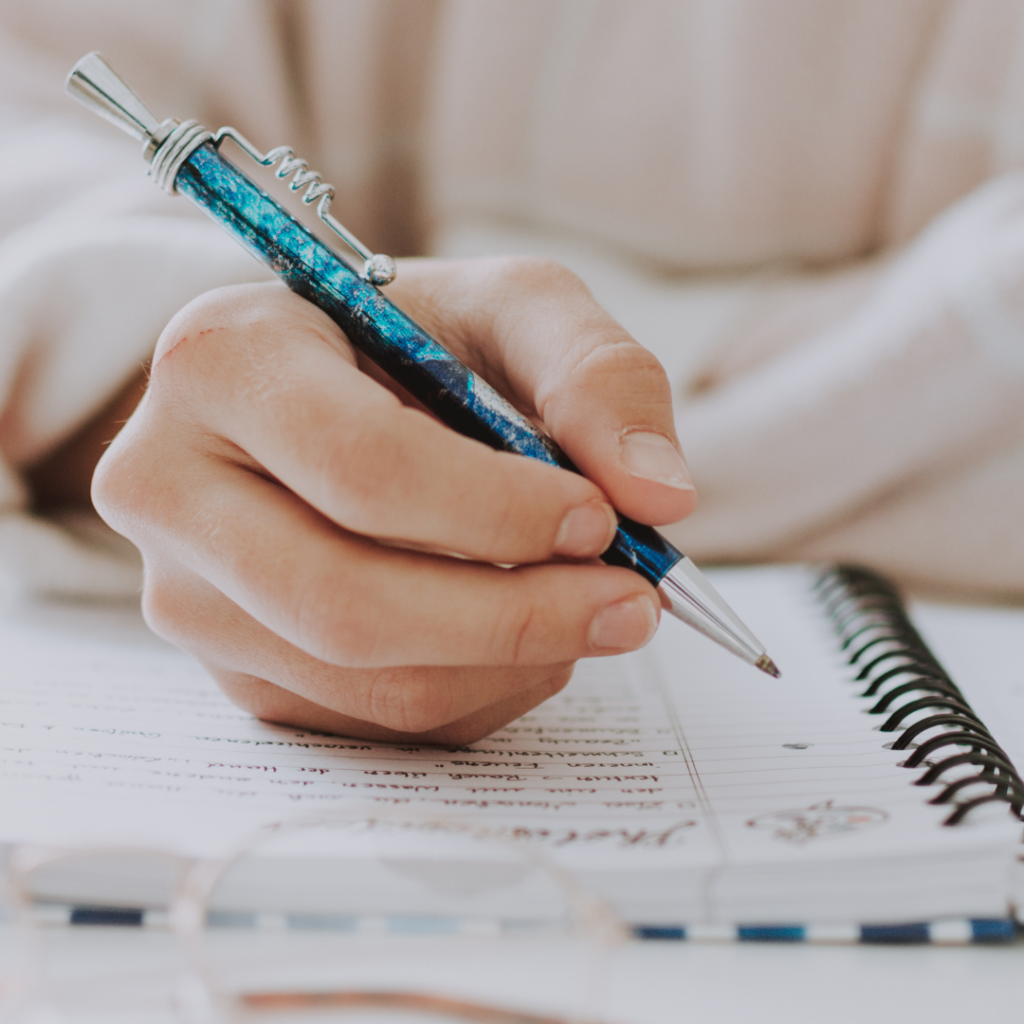 Woman with pen writing notes in notepad