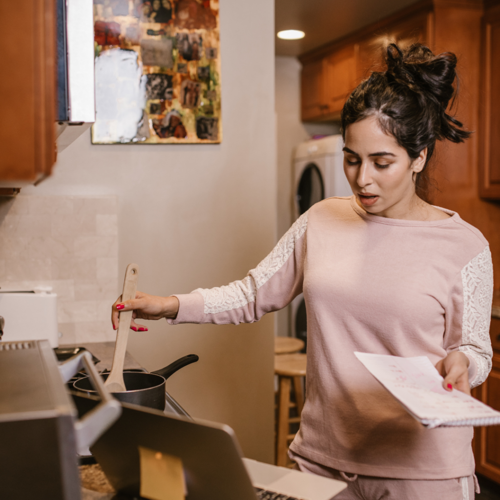 A Woman Cooking and using a Laptop