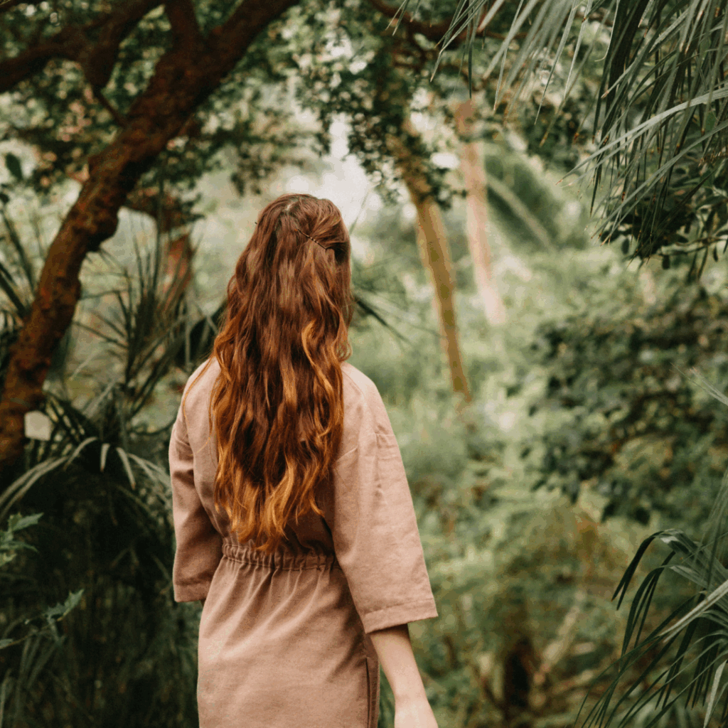 Anonymous woman walking in garden