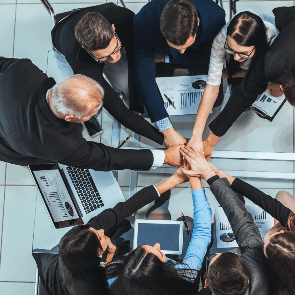 top view. happy employees joining their hands over the desktop