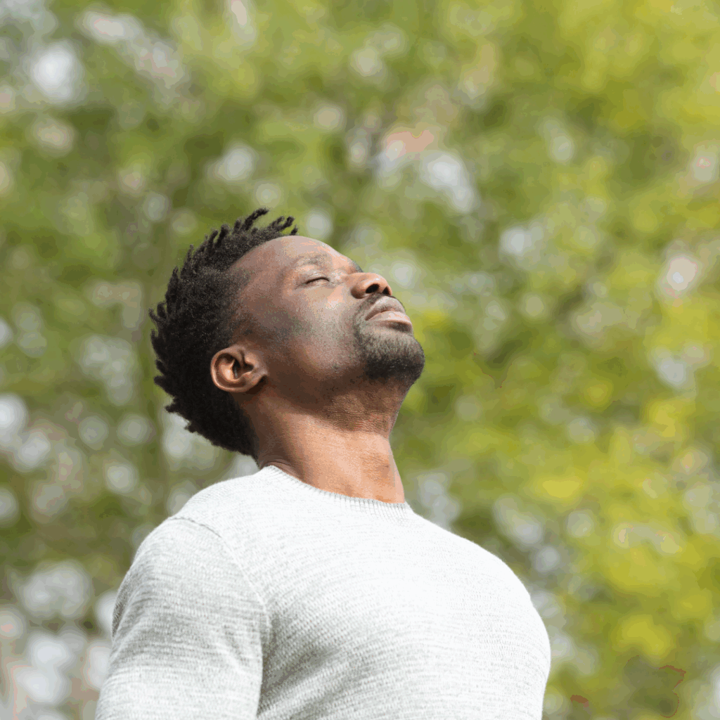 Black serious man breathing fresh air in a park