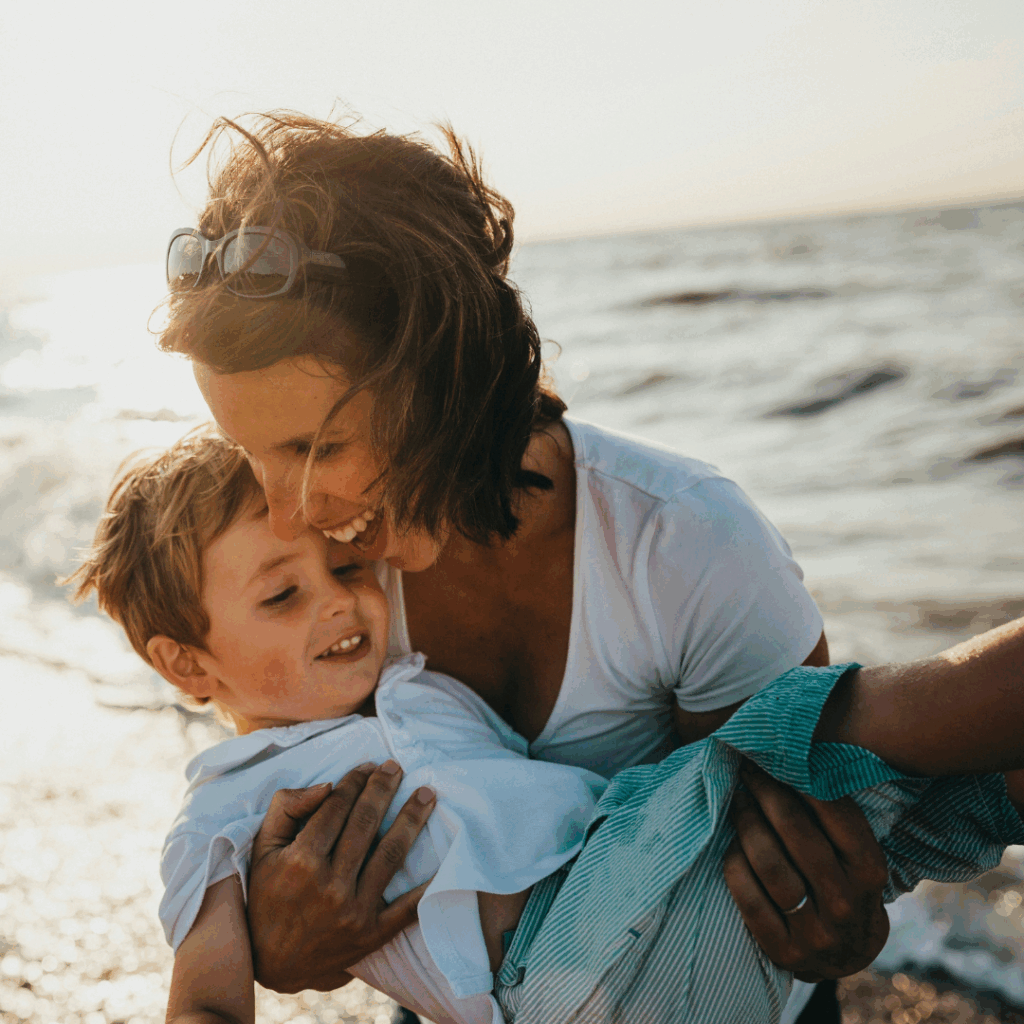 photo of mother and child beside body of water