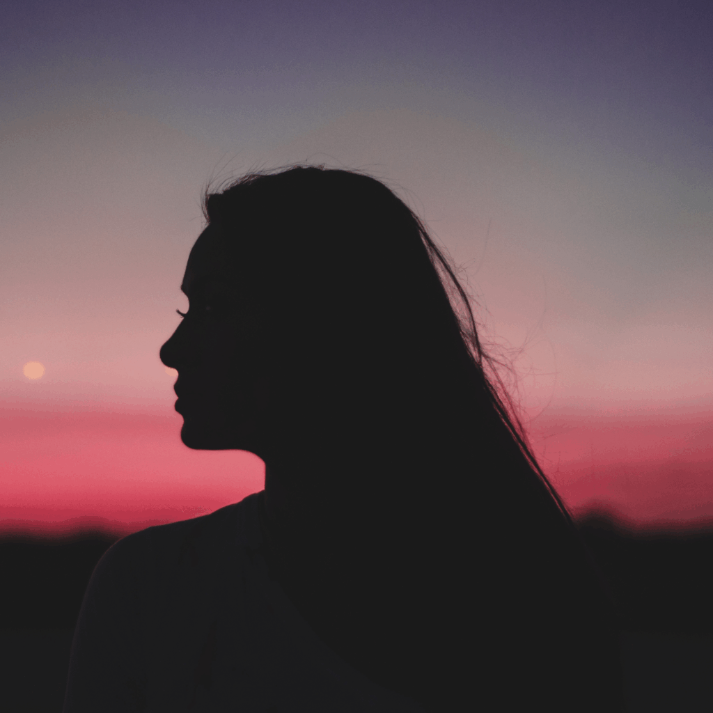 Silhouette of Woman Sideview with Red and Orange Sky