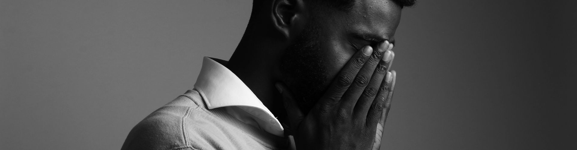 Man Covering His Face with His Hands