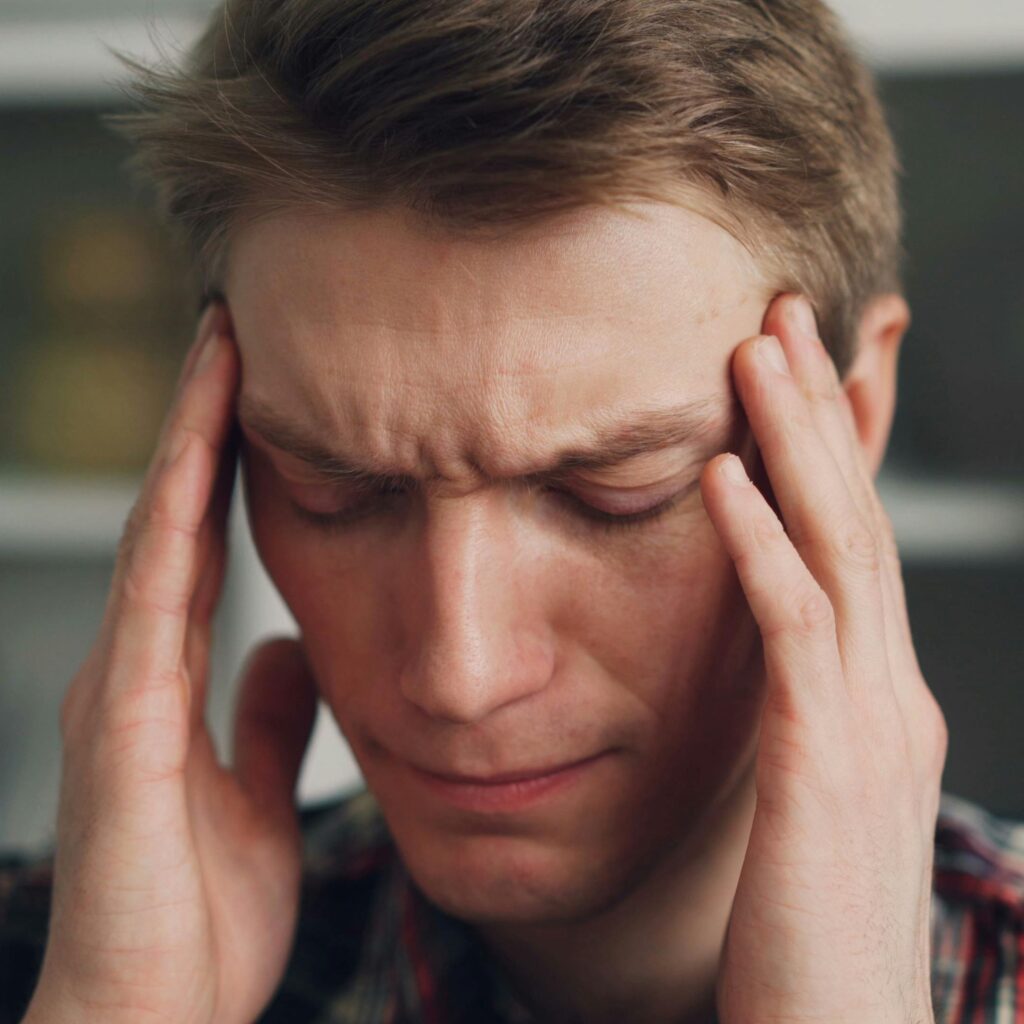 Man Rubbing his Temples with a Worried Look on his Face